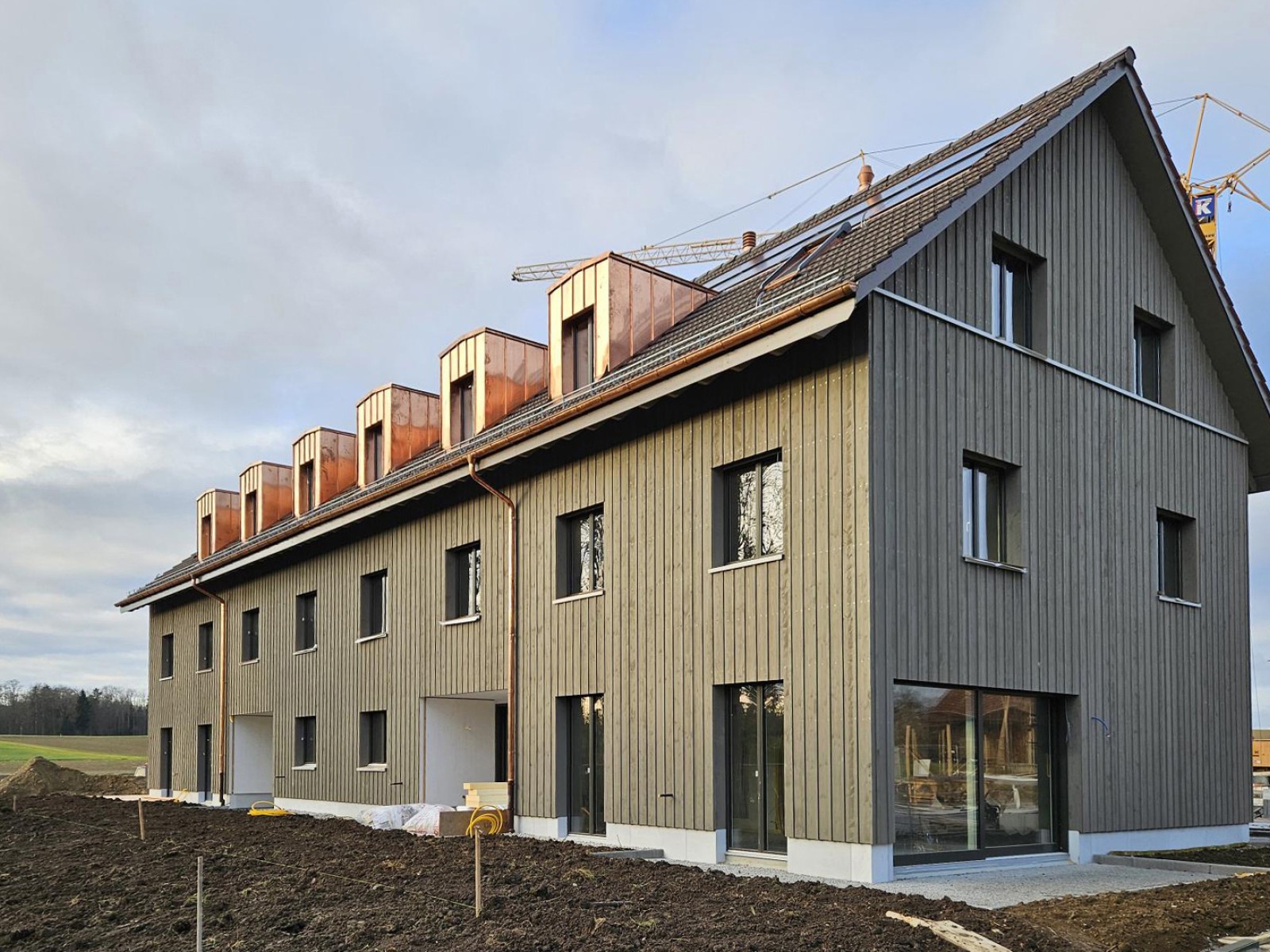 16.12.2024 Die Umgebungsgestaltung um die erste Bautetappe ist bereits weit gediehen… und das Gerüst für die Montage der nächsten zwei Reihenhäuser im Januar ist auch bereits gestellt.