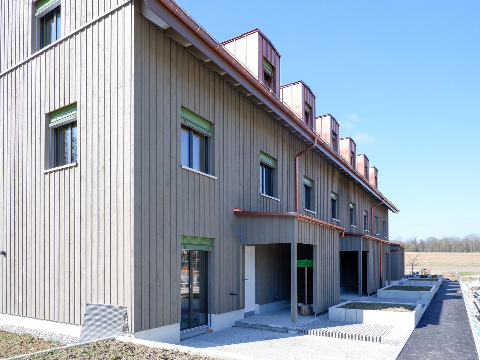 23.04.2025 Die Holzelementbauten der Reihenhäuser 31a-d sind fertig montiert. Nun sind wir daran, deren Gebäudehüllen zu erstellen. Das Tiefgarageneinfahrtsgebäude befindet sich in der Fertigstellung. Parallel dazu sind die Umgebungsarbeiten in vollem Gang und bereits die ersten Bäume gepflanzt. Das Haus 31d ist neu reserviert und das Haus 29b wird ab Mai zum fertig ausgebauten Musterhaus ausgebaut.